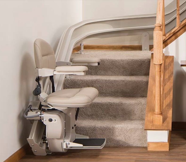 Real chair lift with curved rail on an indoor staircase; equipment example, not a local installation